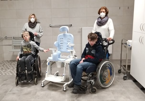 Die Schüler Phil und Florian  freuen sich mit ihren Integrationskräften Frau Schäfer und Frau Görtz über den neuen Duschstuhl.
