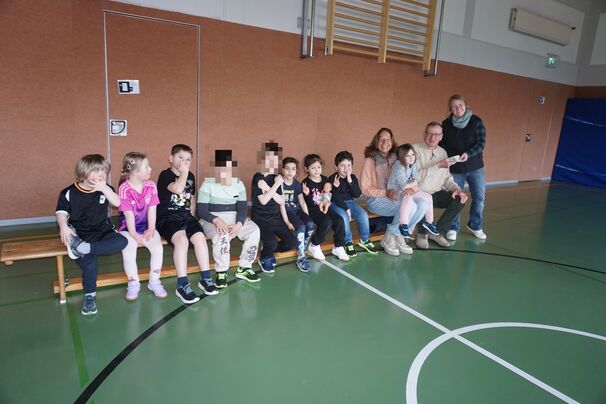 Herr Hinz und Frau Heeger freuen sich mit den Lernenden der Vor-/Unterstufe b über die neue mobile Sandkiste.